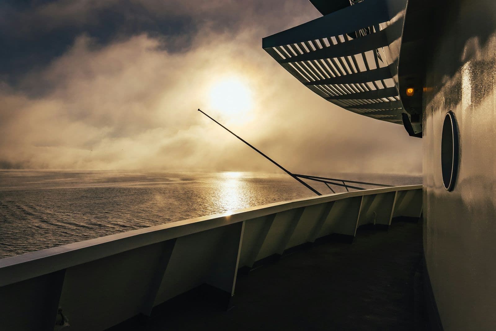 Low sun breaking through sea mist, seen from a ship's deck