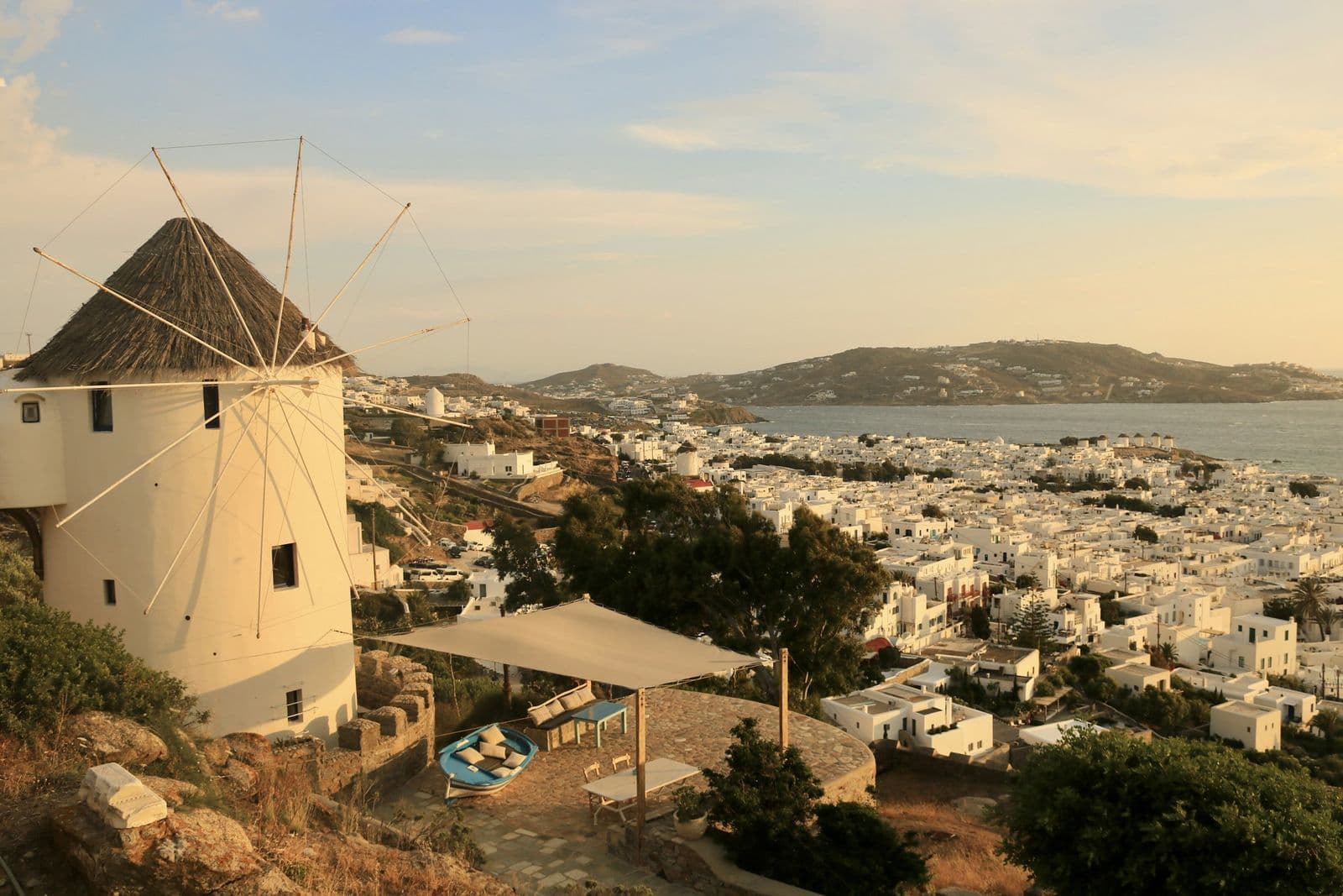 A thatched windmill above the white houses of Mykonos Town and its bay