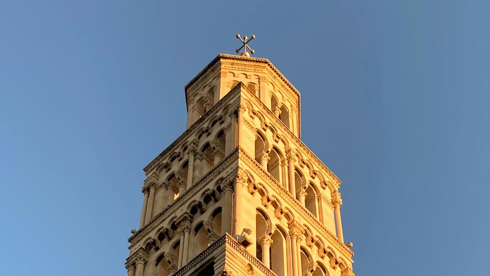The bell tower of the Cathedral of St Domnius in Split, lit gold by low sun
